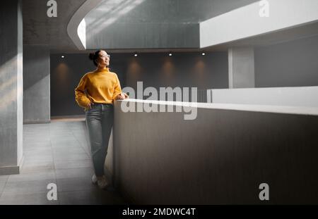 Pensare, mockup e appartamento con una donna asiatica in piedi in un corridoio da solo in attesa di ispirazione. Idea, mock up e corpo pieno con un attraente Foto Stock