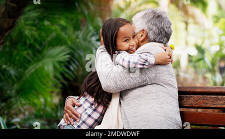 Condividiamo un legame speciale tra noi. una ragazza adorabile che abbraccia la nonna nel parco. Foto Stock