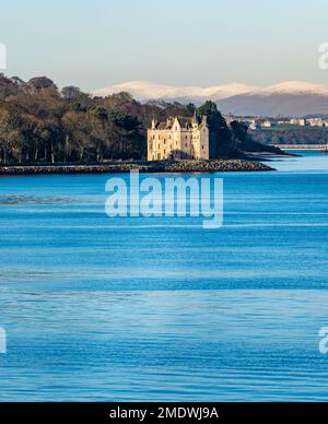 Barnbougle Castle sulla Dalmeny Estate sulla costa del Firth of Forth in una giornata di sole con le colline innevate di Ochill, Scozia, Regno Unito Foto Stock