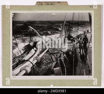 Un combattente della Guardia Costiera si vede combattere attraverso le feroci onde del Nord Atlantico mentre si avvicina una tempesta. La fotografia cattura la potenza e l'imprevedibilità del mare, riflettendo le sfide affrontate dal personale della Guardia Costiera durante le tempeste marine. Foto Stock