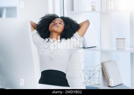 Il lavoro duro paga sempre fuori. una giovane donna d'affari che prende una pausa alla sua scrivania in un ufficio. Foto Stock