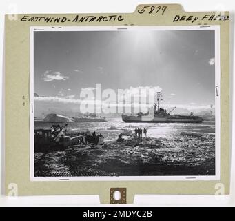 Eastwind - Antartico - Deep Freeze. Cape Hallett, Antartico, 27 febbraio 1960—questa giornata trova il rompighiaccio della Guardia Costiera Eastwind che scarica le forniture e le attrezzature per il personale di svernamento presso la stazione di ricerca scientifica di Cape Hallett. È stato il suo ultimo lavoro nell'operazione Deep Freeze della Marina del 1960 dopo più di 60 giorni di attività come scorta per le navi da carico della Navy Task Force 43, frantumazione del ghiaccio, Consegna di merci e personale alle basi e ad altri compiti per gli avamposti antartici degli Stati Uniti prima di iniziare il viaggio di ritorno a Boston, Mass. Foto Stock