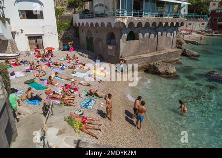 La gente nuota e prende il sole in estate sulla spiaggia di Capri, Baia di Napoli, Mar Tirreno, Italia. Foto Stock