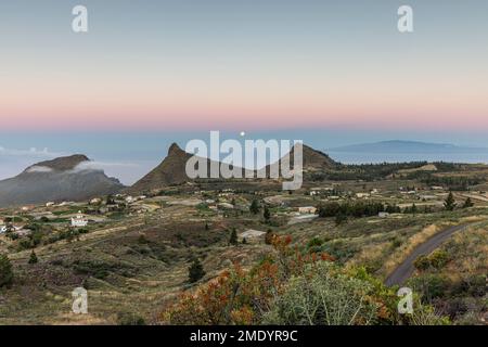 Vista sul villaggio di Ifonche alle località costiere di Los Cristianos e Las Americas all'alba con la luna piena impostazione a ovest, Adeje, Tene Foto Stock
