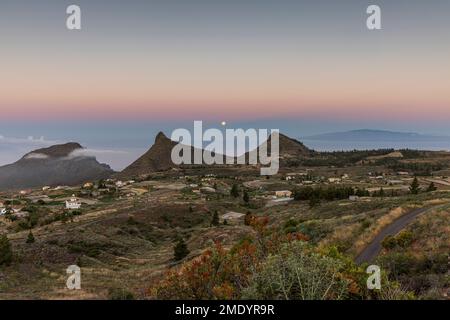 Vista sul villaggio di Ifonche alle località costiere di Los Cristianos e Las Americas all'alba con la luna piena impostazione a ovest, Adeje, Tene Foto Stock