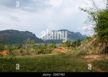 Terra rossa, ricca di ferro nella Valle de Palmarito, Viñales, Cuba, con piccoli edifici nella valle. Foto Stock