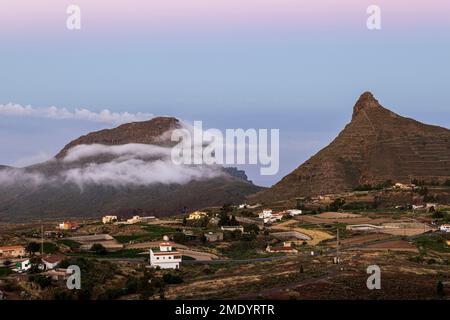 Vista sul villaggio di Ifonche alle località costiere di Los Cristianos e Las Americas all'alba con la luna piena impostazione a ovest, Adeje, Tene Foto Stock