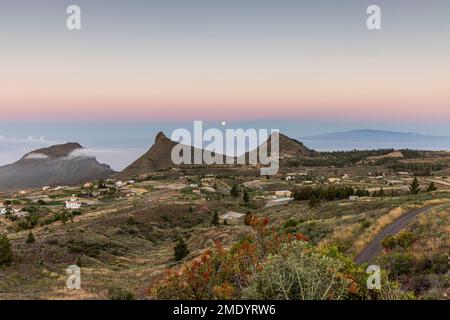 Vista sul villaggio di Ifonche alle località costiere di Los Cristianos e Las Americas all'alba con la luna piena impostazione a ovest, Adeje, Tene Foto Stock