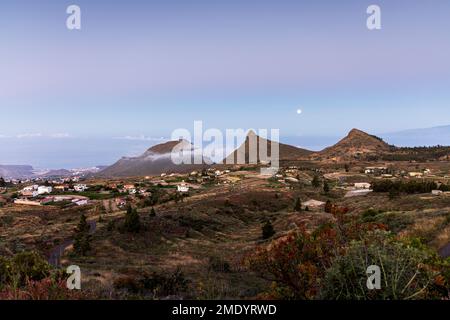 Vista sul villaggio di Ifonche alle località costiere di Los Cristianos e Las Americas all'alba con la luna piena impostazione a ovest, Adeje, Tene Foto Stock