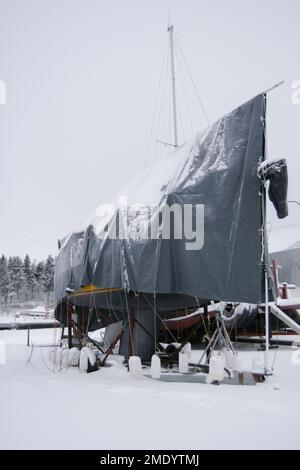 Foto invernali innevate scattate a Tampere, Finlandia. Le barche sono ormeggiate sulla riva e coperte di neve e ghiaccio. L'inverno è arrivato e sembra gelido. Foto Stock