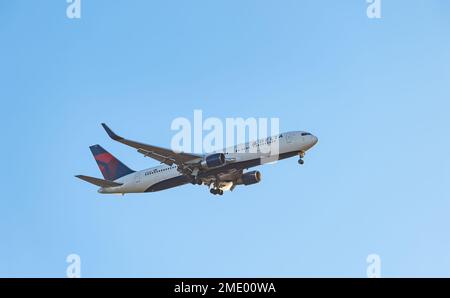 Delta Airlines aereo che scende a terra con carro contro un cielo azzurro chiaro, Scozia, Regno Unito Foto Stock