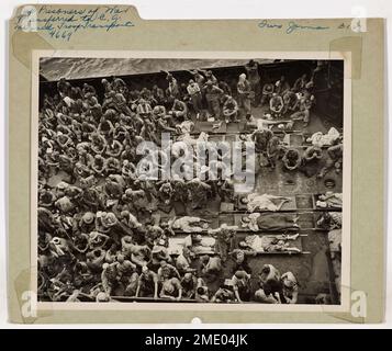 Fotografia dei prigionieri di guerra giapponesi a bordo del trasporto della truppa con equipaggio della Guardia Costiera. I prigionieri di guerra Jap sono trasferiti al trasporto della truppa con equipaggio della Guardia Costiera. Un'ulteriore indicazione che non tutta la lotta giapponese alla morte è questa borsa di 221 prigionieri di guerra. Sgranati sul ponte di un LCT (Landing Craft, Tank), sono stati portati a una guardia costiera con equipaggio truppa di trasporto a Guam per il trasferimento a Pearl Harbor. Trenta dei prigionieri furono portati a Guam, mentre l'equilibrio fu catturato a Iwo Jima. Alcuni feriti giacciono sulle barelle. Per la maggior parte i prigionieri erano magri, indicando che anche Th Foto Stock