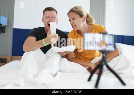 Una coppia di turisti arrabbiati chiama la reception e si lamentano con il personale dell'hotel per problemi nella camera. Foto Stock