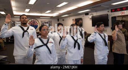 I marinai e i familiari con sede a Sasebo si impegnano a dare il giuramento di naturalizzazione di Allegiance agli Stati Uniti d'America durante una cerimonia di naturalizzazione al Comandante, Fleet Activities Sasebo (CFAS) 27 luglio 2022. STATI UNITI Citizenship and Immigration Services and Region Legal Service Office Western Pacific ha collaborato per condurre la cerimonia di naturalizzazione al CFAS consentendo ai marinai di diventare cittadini degli Stati Uniti. Foto Stock