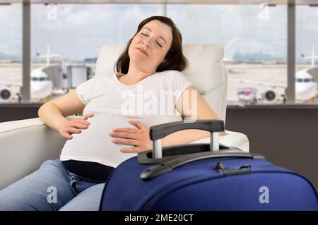 Donna incinta che dorme e attende il suo volo in una zona VIP e nell'aeroporto della zona VIP Foto Stock