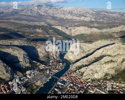 Vista aerea del drone della città di Omis in Croazia. La posizione è il punto di incontro tra il fiume Cetina e il mare Adriatico. Bellissima città vicino alle montagne. Foto Stock