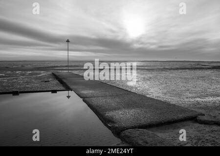 Immagine in bianco e nero di Bell Wharf Beach a Leigh-on-Sea, Essex, Inghilterra, Regno Unito in una giornata invernale Foto Stock