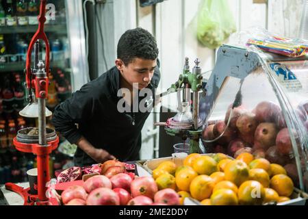 Scena di strada con un ragazzo che prepara succo di melograna a Betlehem, Israele, Asia. Foto Stock