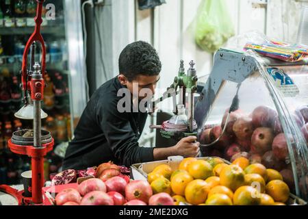 Scena di strada con un ragazzo che prepara succo di melograna a Betlehem, Israele, Asia. Foto Stock