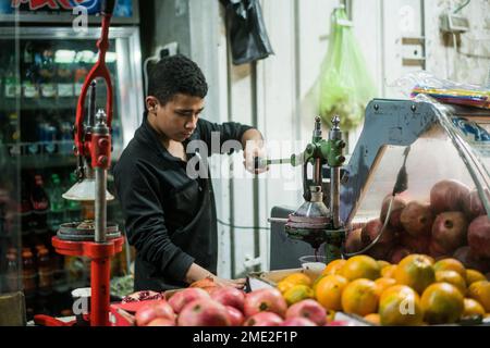 Scena di strada con un ragazzo che prepara succo di melograna a Betlehem, Israele, Asia. Foto Stock