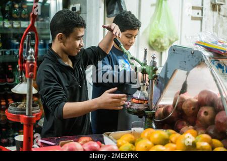 Scena di strada con un ragazzo che prepara succo di melograna a Betlehem, Israele, Asia. Foto Stock