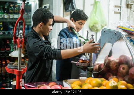 Scena di strada con un ragazzo che prepara succo di melograna a Betlehem, Israele, Asia. Foto Stock