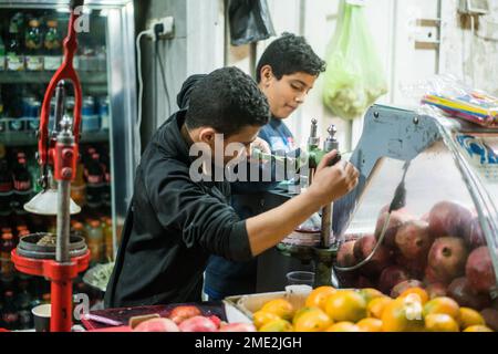 Scena di strada con un ragazzo che prepara succo di melograna a Betlehem, Israele, Asia. Foto Stock