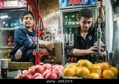 Scena di strada con un ragazzo che prepara succo di melograna a Betlehem, Israele, Asia. Foto Stock