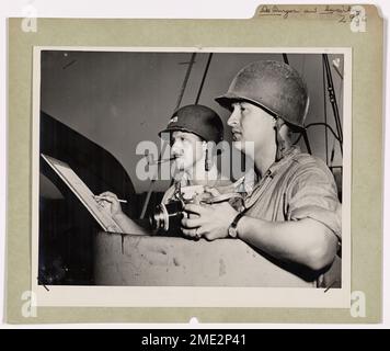 Local Coast Guardsman 'copre' Southwest Pacific Invasion. Ralph De Burgos (a sinistra), Seaman First Class, di 8015 Eastern Avenue, Silver Spring, Maryland, e il fotografo di combattimento della Guardia Costiera Eugene S. Swierkosz, fotografo Mate Second Class, di 138 Lester Avenue, Johnson City, New York, servono a bordo di un LST con equipaggio della Guardia Costiera nelle invasioni del Pacifico sud-occidentale. Questa squadra di combattimento era a Morotai negli Halmaheras. Foto Stock