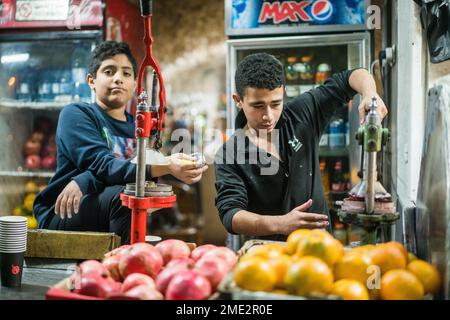 Scena di strada con un ragazzo che prepara succo di melograna a Betlehem, Israele, Asia. Foto Stock