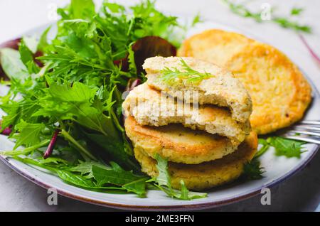 Frittelle tofu, cibo vegetariano, pancake di fagioli di soia, antipasto salato con insalata fresca su un piatto su sfondo luminoso Foto Stock