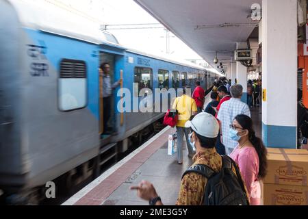 I passeggeri in attesa che il treno arrivi al binario si fermano Foto Stock