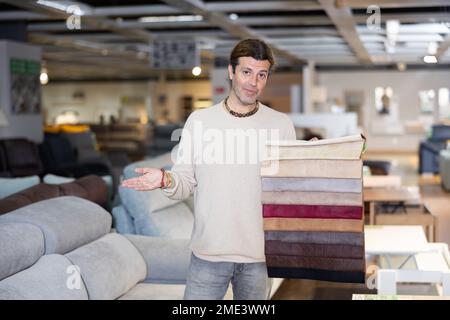 Uomo di mezza età mostra tessuto di tappezzeria Foto Stock