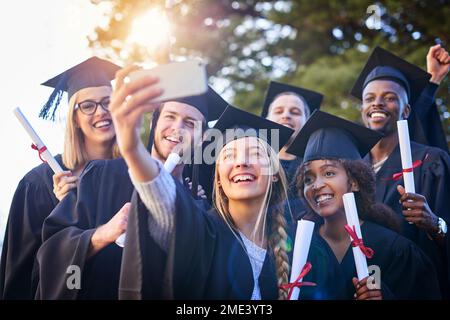 Abbiamo tutti i motivi per sentirci orgogliosi. un gruppo di studenti universitari che prendono un selfie il giorno della laurea. Foto Stock