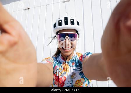 Ciclista felice prendendo selfie davanti al muro nella giornata di sole Foto Stock