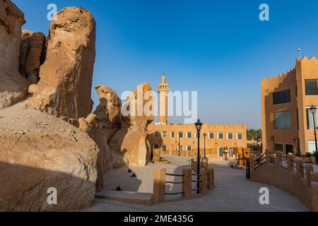 Arabia Saudita, Provincia Orientale, al-Hofuf, affioramenti di arenaria con moschea sullo sfondo Foto Stock