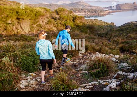 Coppia di corridori del sentiero che scende in montagna Foto Stock