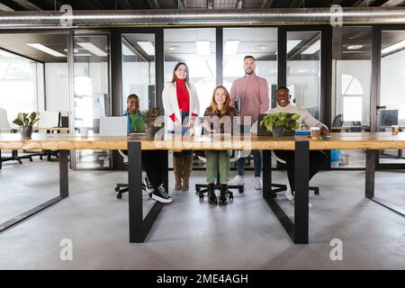 Donne d'affari multirazziali sorridenti e uomini d'affari in ufficio di coworking Foto Stock
