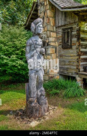 Scultura di Boone all'esterno della cabina Daniel Boone presso l'Accademia e Villaggio di Whippoorwill a Ferguson, North Carolina. Foto Stock