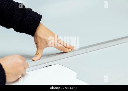 Mani dell'artigiano che misura il tessuto in officina Foto Stock