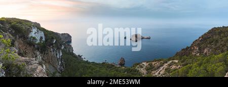 Spagna, Isole Baleari, Vista panoramica dell'arco roccioso di Ses Margalides e del mare circostante al tramonto visto dalla scogliera costiera Foto Stock