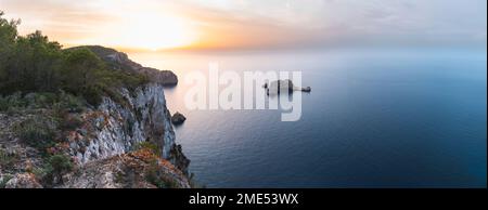 Spagna, Isole Baleari, Vista panoramica dell'arco roccioso di Ses Margalides e del mare circostante al tramonto visto dalla scogliera costiera Foto Stock