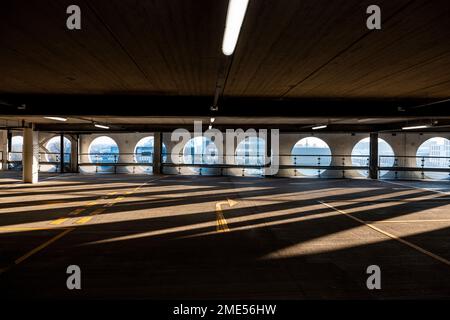 Regno Unito, Inghilterra, Manchester, Arches che gettano ombre in un parcheggio vuoto a più piani Foto Stock