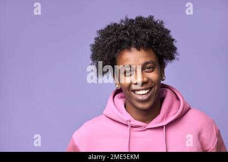 Ragazzo afro-americano sorridente che indossa felpa con cappuccio rosa isolato sul viola. Foto Stock