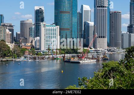 Brisbane, Australia – Gennaio 19 2023: Pontile con grande gru da cantiere sul Fiume Brisbane con edifici cittadini sullo sfondo Foto Stock