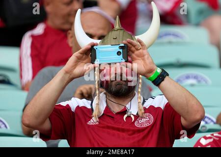 A Denmark team fan, his face in the colours of the Danish national flag, takes photos as he waits for the start of the Euro 2020 soccer championship quarterfinal match between Czech Republic and Denmark, at the Olympic stadium in Baku, Saturday, July 3, 2021. (AP Photo/Darko Vojinovic, Pool)