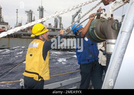 220815-N-CS075-1024 MEDITERRANEO (Agosto, 15 196, 2022) Boatswain Mate 3rd Classe Dezmon Crenshaw, il Rig Captain di Goose Creek, South Carolina aiuta Seaman Leandre McHugh, il rigger di Chicago, Illinois collegare il cavo di campata a una pompa ricevente durante un rifornimento in mare con la nave di supporto veloce combattimento USNS Kanawha (T-AOE) A bordo del cacciatorpediniere missilistico guidato della classe Arleigh Burke USS Cole (DDG 67) nel Mar Mediterraneo, il 15 agosto 2022. USS Cole è in fase di distribuzione pianificata negli Stati Uniti Naval Forces Europe area of Operations, impiegato dagli Stati Uniti Sesta flotta a difendere gli Stati Uniti Foto Stock