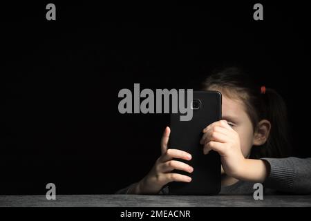 Addiction e insonnia dei gadget capretti, problemi psicologici, sfondo nero, spazio di copia Foto Stock