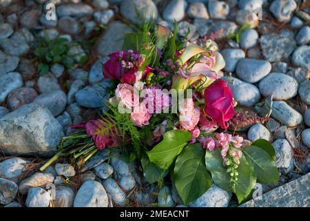 Fiori di nozze, mazzo nuziale closeup con rose e gigli su uno sfondo di Pebble and Rock Foto Stock