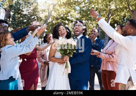 Confetti di nozze, coppia di matrimonio e celebrazione del pubblico che lancia petali di fiori all'aperto. Felicità, evento emozionato e sociale con la sposa e l'uomo Foto Stock